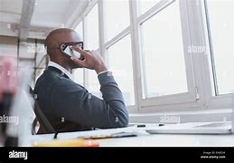 Image result for A Black Man Sitting as a Desk Talking On a Telephone Photos