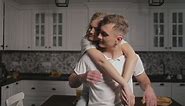 Woman gives man thank you hug in kitchen - Free Stock Video