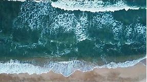 Aerial view of sand beach. Top view sea waves. Drone footage