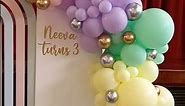 Pastel rainbow backdrop with balloon arch. #