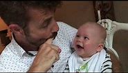 Baby laughing hysterical while dad pops his mouth