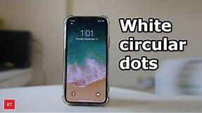 White circular dots on the upper left corner of the iPhone