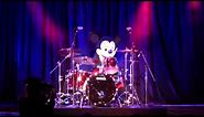 Mickey Mouse plays the drums at the D23 Expo with a live band on stage