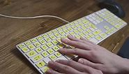 Close-up of a computer keyboard with braille. A blind girl is typing words on the buttons with her hands. Technological device for visually impaired people. Tactilely touches bumps on the keys