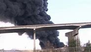 Massive warehouse fire sends thick column of black smoke into the air