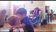 Toddler hugging and kissing a crying baby