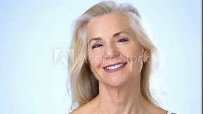 Closeup portrait headshot 50s, 60s old middle-aged mature senior aging Caucasian woman grandma older lady model with long shiny smooth gray hair smiling looking at camera haircare