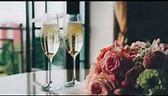 Wedding rings fall into glasses of champagne, slow motion. Wedding bouquet, wedding background.