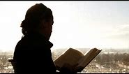 Silhouette of a person reading a book.