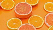 Zesty slices of citrus fruits on an orange background. - Free Stock Video