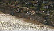 Worst tidal surge in 60 years batters UK east coast and drags homes into the sea