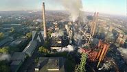 Mesmerizing aerial footage of a chemical factory with smoke stacks, captured by a drone, showcasing the environmental impact of industrial pollution.