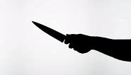 Man Holding Knife Closeup Shadow Silhouette of Hand with Weapon