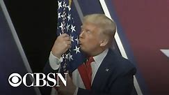 Trump hugs and kisses the American flag at CPAC 2020
