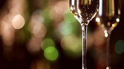Champagne. Two Flutes with Sparkling Champagne over Christmas Holiday Bokeh Blinking Background.