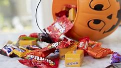 Trick-or-treaters refill empty candy bowl