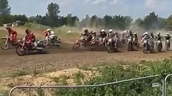 A wild crash takes place during a dirt bike motocross race.