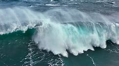 Aerial shot of powerful tsunami wave. Slow motion of big sea or ocean surf wave crashing. UD, 4K.
