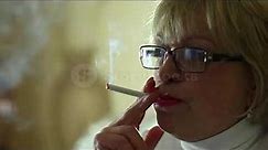 Senior woman with glasses smoking a cigarette, female smoker, close up shot