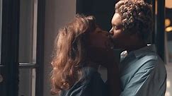 Lesbian couple kiss passionately indoors young millennial lgbt couple kiss near window. African-American and caucasian girlfriends kiss and hug. Lgbtq relationship. Realtime