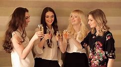 Beautiful girls clink glasses of champagne in the birthday