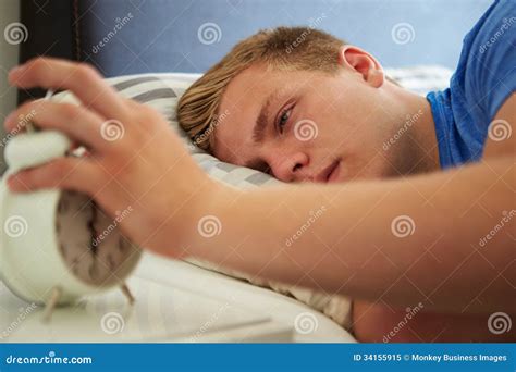 tienerontwaken  bed en het uitzetten van wekker stock afbeelding image  horizontaal