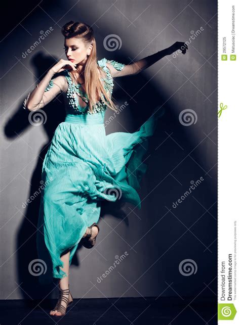 beautiful woman in green dress posing dramatic indoors