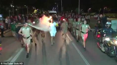 protester attempts to put out olympic flame with a fire extinguisher