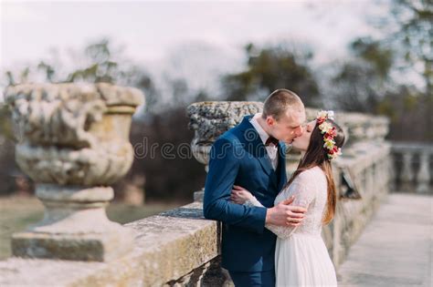 Charming Newlywed Bride And Groom Kissing At Old Terrace