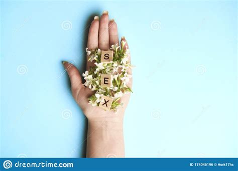 woman hand with three wooden blocks letters sex on them flowers