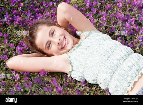 smiling pre teen girl lying arms  head  field  flowers stock photo  alamy