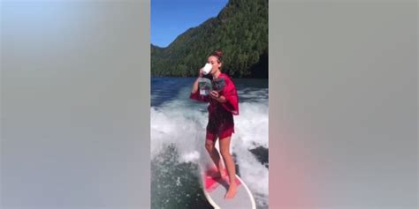 Surfing Stunner Woman Wakesurfs On Lake In High Heels Sips Coffee