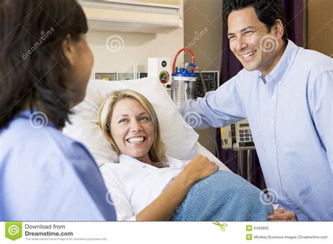 Doctor Talking To Pregnant Woman And Her Husband Stock