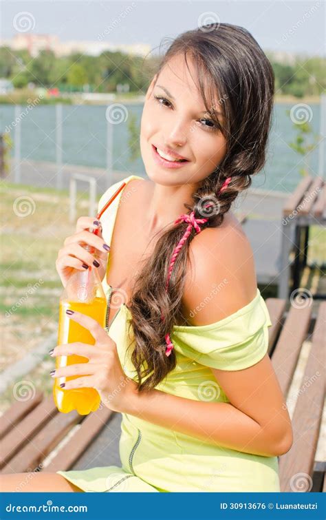 Beautiful Brunette Girl Holding A Plastic Bottle With Orange Juice