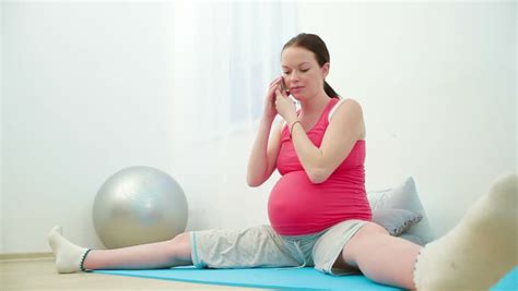 pregnant girl is sitting on the floor doing exercises meditating stock footage video 10493336