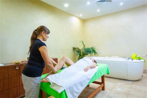 professional therapist giving relaxing reflexology thai oil leg massage