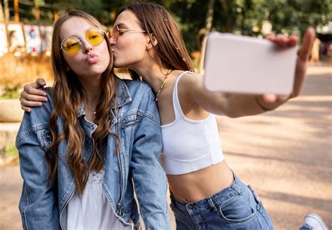 free photo girlfriends taking selfie while kissing on cheek