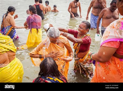 women and men praying and bathing in the ghats of ganges river