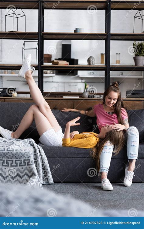 Two Smiling Lesbians On Sofa In Cozy Living Room Stock Image Image