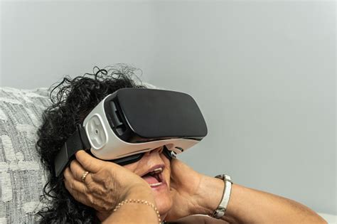 senior brunette curly haired woman gaping in the virtual reality