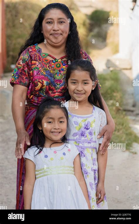Latin Mother With Her Two Happy Daughters Outside Her House In Rural