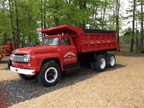 red dump truck parked  top   gravel road