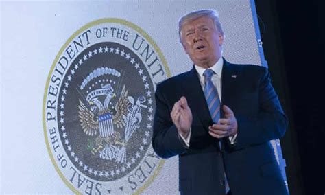 trump stands before presidential seal doctored with symbols of russia