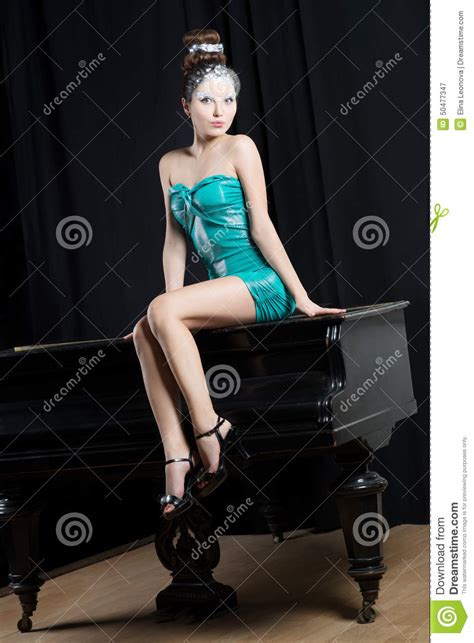Sexual Woman In Short Mini Blue Dress Sitting On The Piano
