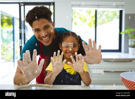 Portrait Of Multiracial Father And Daughter Showing Messy Hands Covered