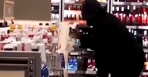thief caught on camera filling entire bag with liquor at