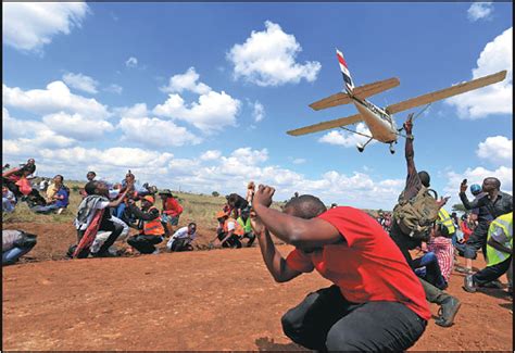 spectators react as a plane flies over them during the vintage air rally at the national park in