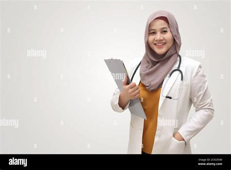 Asian Muslim Female Doctor Wearing Hijab With Stethoscope In White Coat