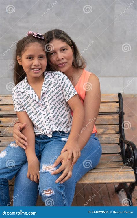 Latin Mother And Daughter Hugging And Smiling At The Camera Stock Image