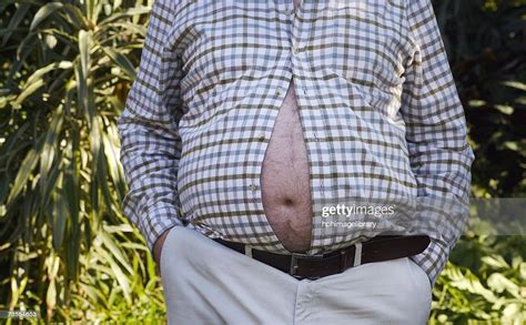 Man With His Large Belly Bursting Through His Shirt Photo Getty Images